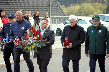 Delegacija nese cvetje in sveče